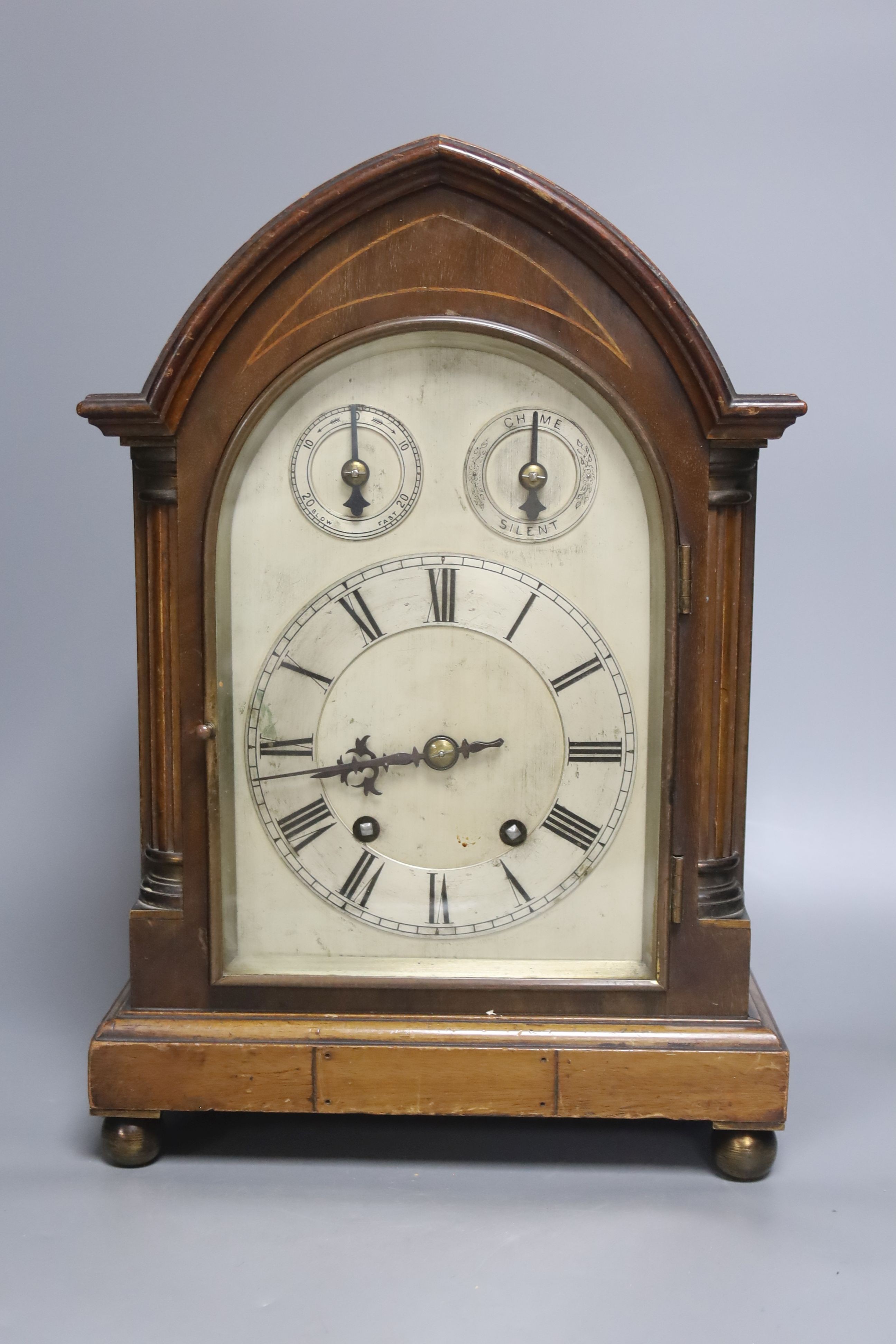 An inlaid mahogany lancet shaped chiming mantel clock with silvered dial, circa 1900. Pendulum and key. 38cm
